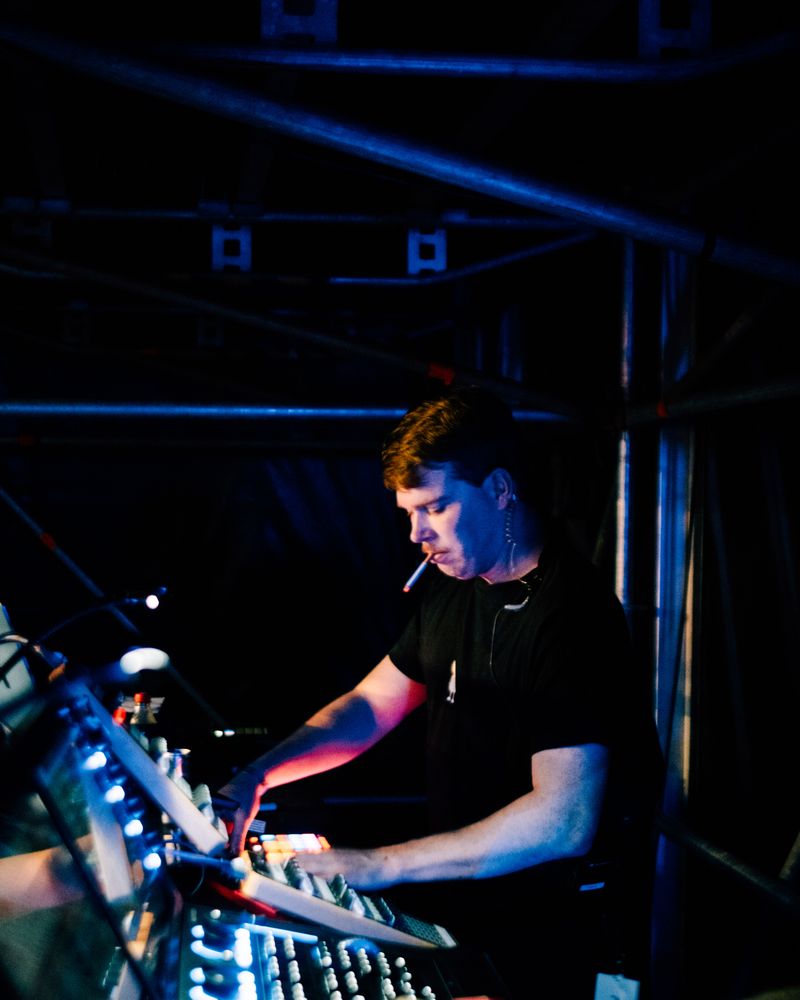 knispolowitz at the video desk under the stage scaffolding, lit by the console